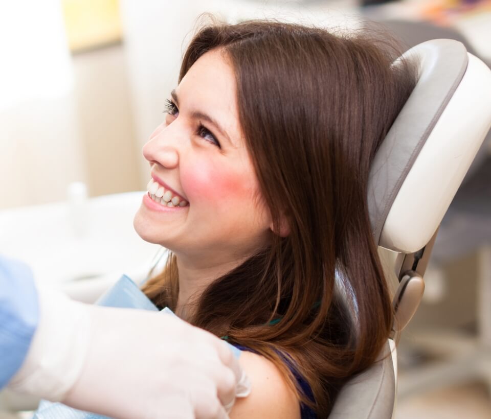 woman smiling while visiting the dentist in Findlay, OH