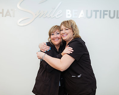 two staff members from Anderson Family Dentist hugging