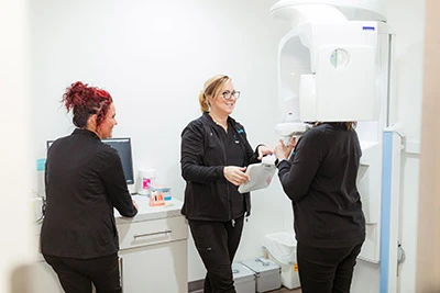 Staff members speaking to a patient in a x-ray machine